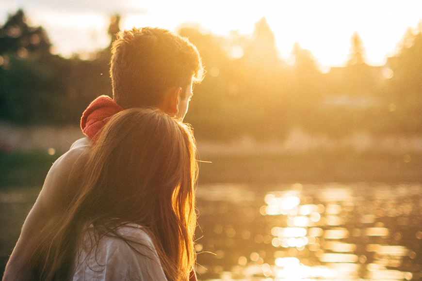 young couple enjoying sunset over bellinger river at mylestom cabins accommodation coffs harbour